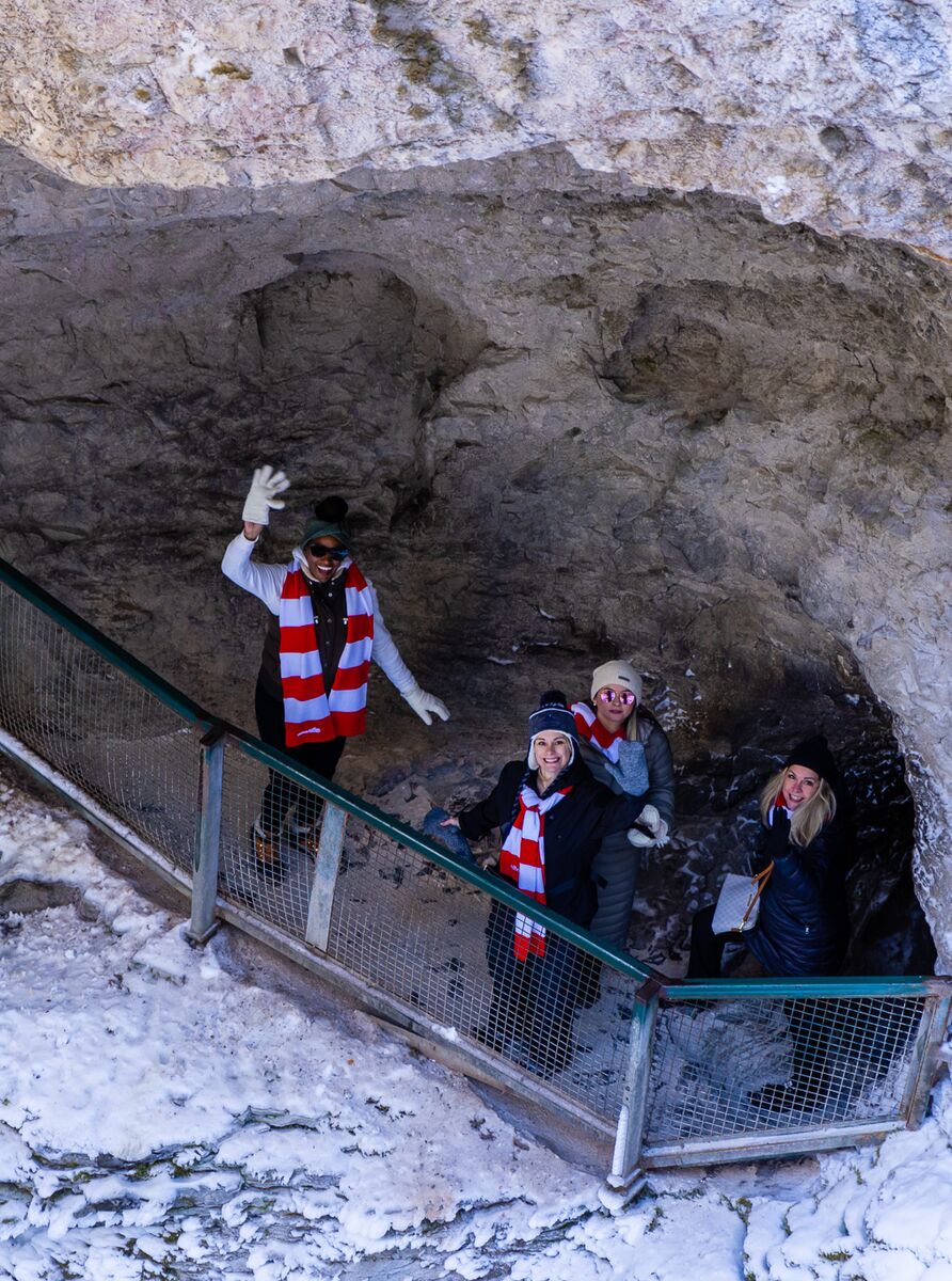 People wave from a cave on Johnston Canyon trail in winter in Banff National Park.